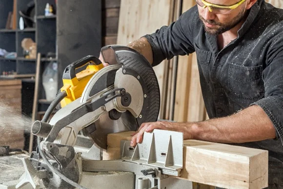 Person sägt Holz mit Kreissäge